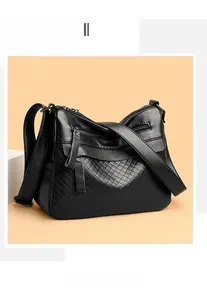 Detail of black lychee texture shoulder bag featuring diamond quilted pattern and zippers