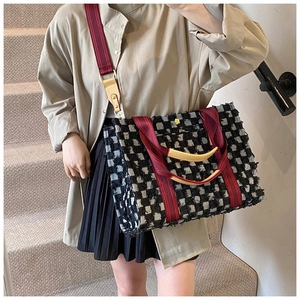Détail du sac cabas à carreaux avec franges et bandoulière bordeaux sur le mannequin