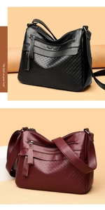 Detail of lychee pattern leather bags in black and wine red with quilted textures