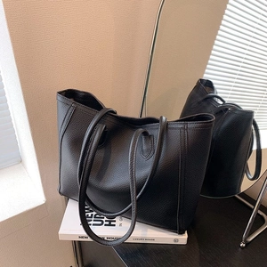 Black lychee grain leather tote bag with large capacity shown in a minimalist scene