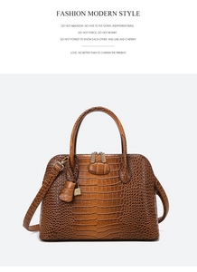 Detail of dark brown faux crocodile leather tote bag with gold lock and double handles