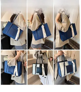 Detail view of large canvas tote bag showing stitching and chic ribbon decor in blue tones