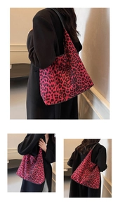 Detailed view of leopard print tote bag in red and black paired with a long wool coat