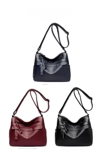 Three textured crossbody bags in blue, red, and black with rhombic patterns and tassels