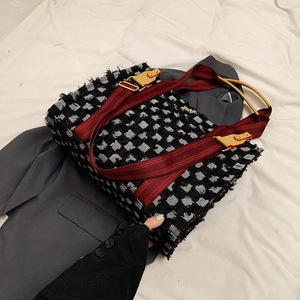 Détail du sac cabas en tweed damier avec poignée anneau métal et sangle rouge