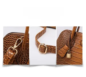 Detail of adjustable strap gold hardware and brown crocodile embossed leather texture
