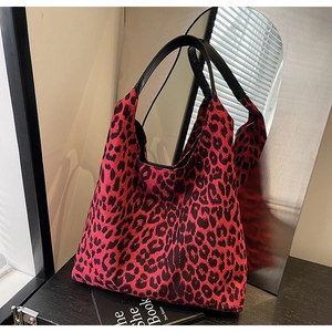 Detail of a large pink leopard print tote bag with black leather handles for women
