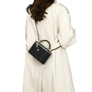 Quilted black leather crossbody bag with golden bee motif and chain strap on model