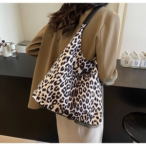 Macro detail of high-quality leopard print tote bag with leather straps on a casual outfit