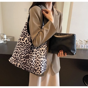 Detail of leopard print tote bag and black zipper pouch set shown with a model