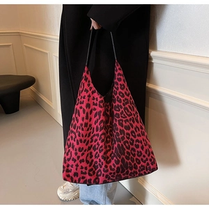 Detailed view of leopard print shoulder bag with black strap and geometric tote structure