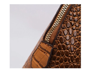 Detailed close-up of brown crocodile texture leather and premium gold metal zipper