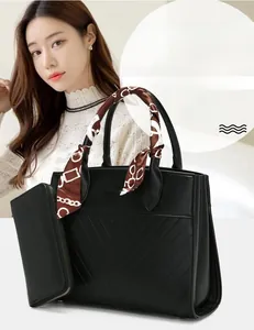 Detail view of black tote bag with V-shaped stitching and silk scarf handle accent