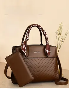 Detail of brown PU leather tote bag with V-quilted texture and silk scarf handle