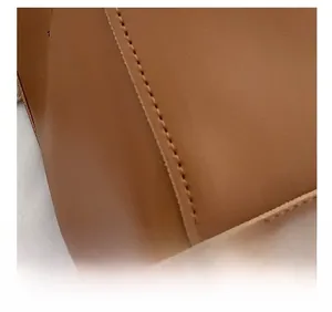 Close-up of brown leather bag with precise stitching and fine texture details