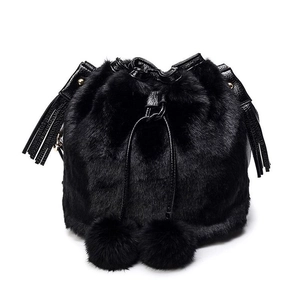 Detail of black faux fur bucket bag with plush pom-poms and drawstring closure