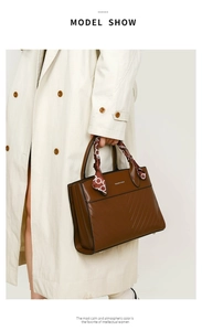 Brown tote bag with diagonal textured leather pattern and decorative silk scarf detail