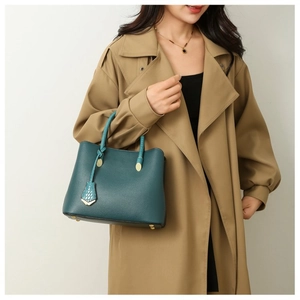 Macro shot of dark green lychee pattern leather tote bag with elegant gold hardware buckles