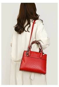 Detail of red quilted leather tote bag with silk scarf handle and adjustable strap
