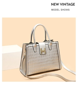 Detail of crocodile embossed tote bag with iconic metal H buckle and dual top handles