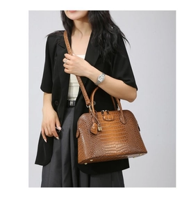 Detail shot of brown crocodile pattern shoulder bag on model with adjustable strap