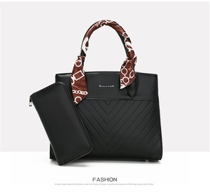 Detail of black quilted tote bag with matching long wallet and silk scarf handle decor