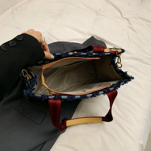 Sac fourre-tout en denim bleu matelassé avec anses rayées et bords effilochés en vue de dessus