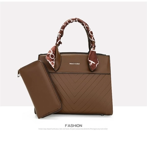 Detail of brown leather tote bag with V-shaped embossing and matching long wallet set