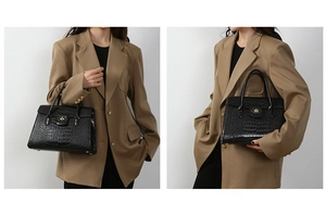 Detail of black crocodile-embossed tote bag featuring gold-tone clasp and top handles