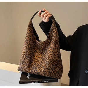 Women's leopard print tote bag with black leather handles in classic trapezoid design