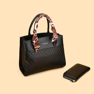 Detail of black V-quilted tote bag and matching long wallet with silk scarf accessory