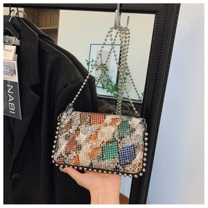 Detail of colorful snakeskin texture with silver rivets and metallic ball chain strap