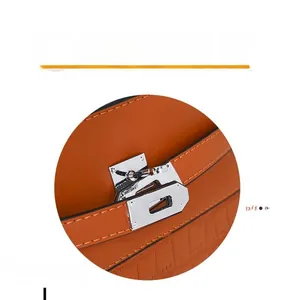 Close-up of orange crocodile pattern leather handbag with a silver rotating metal clasp