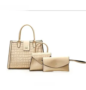 Detailed front view of three-piece champagne gold tote bag set with crocodile texture