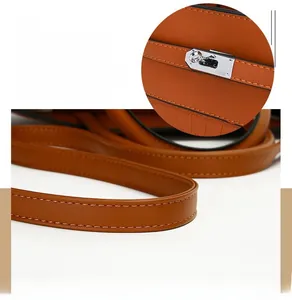 Detailed close-up of caramel leather handbag featuring fine stitching and metal lock hardware