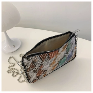 Detail view of colorful snakeskin textured crossbody bag with metal ball chain and zip