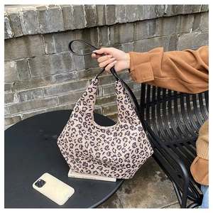 Detail of hobo bag with leopard print and black strap in a stylish cafe setting