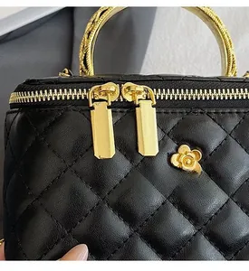 Detail of classic black quilted leather texture with smooth golden flower zipper and hardware