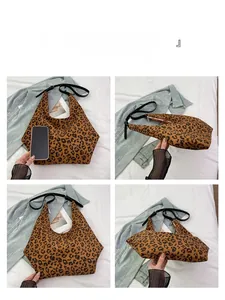 Detail view of large leopard print dumpling bag with black strap and spacious interior