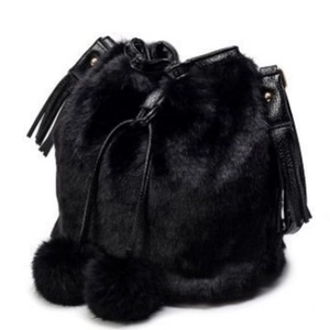 Faux fur drawstring bucket bag in black with plush pom-poms and leather tassel