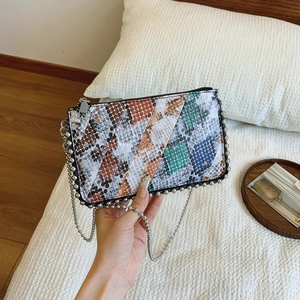 Detail of colorful snakeskin pattern texture with silver beaded chain and metal strap