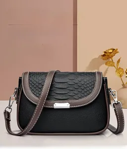 Détail des coutures en cuir noir grainé et serpent sur le sac à bandoulière