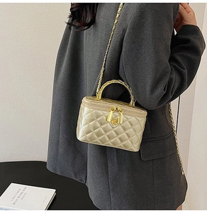 Detail of champagne gold quilted mini bag with metal chain strap and top handle