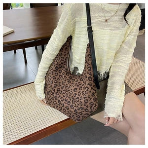 Detail view of leopard print hobo bag with slim leather strap in casual lifestyle setting