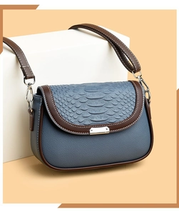 Détail du sac bandoulière en cuir bleu à motif serpent et boucle métallique élégante