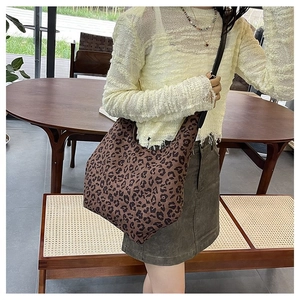 Detail of leopard print crescent bag with black leather strap in a lifestyle setting