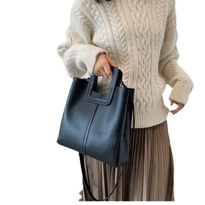 Minimalist black leather crossbody bag with U-shaped handle and adjustable strap for women