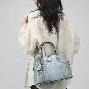 Light blue faux crocodile skin handbag with golden hardware and adjustable strap