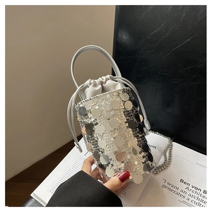Close-up of silver sequin bucket bag featuring drawstring lining and metal chain strap