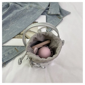 Close-up of silver bucket bag with drawstring liner showing storage capacity for small items